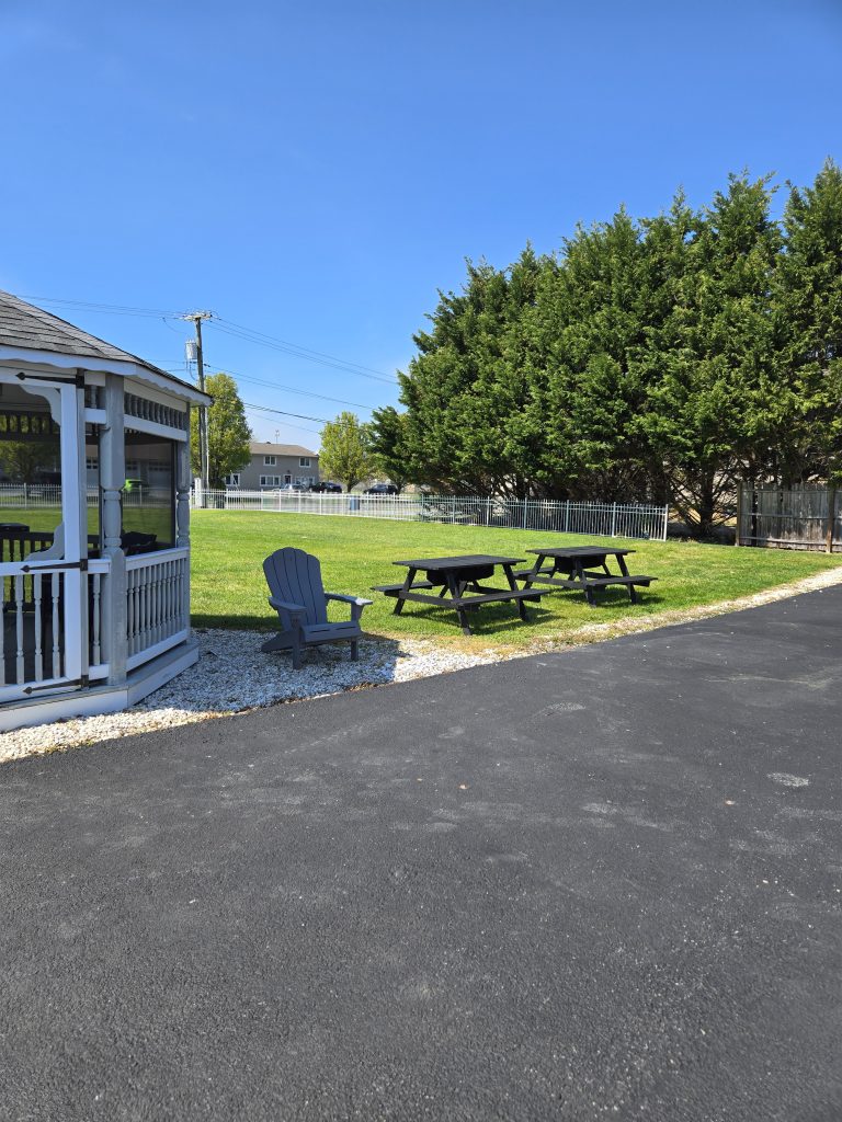Outdoor seating area next to a gazebo and lush green lawn