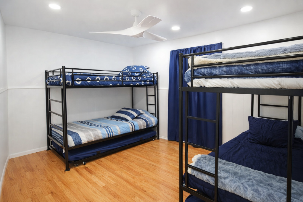 Front bedroom photo gallery: Bunk beds with blue bedding in a bright, modern room with wood floors and a white ceiling fan.
