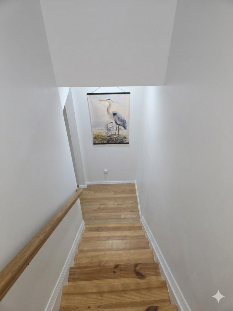 Master bedroom photo gallery: Wooden stairs with natural light and heron artwork. Modern home interior design.